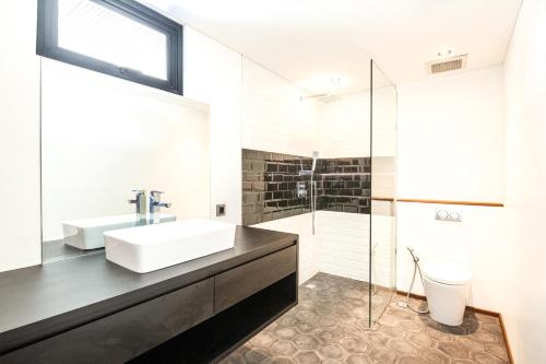 a bathroom with a sink and a shower at Modern Spacious Loft 200m From The Beach Canggu in Canggu