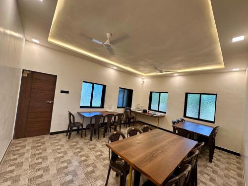 a conference room with tables and chairs and windows at Sapphire Mansion in Alibag