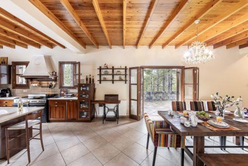 a kitchen with a wooden ceiling and a dining room at Troodos Mature Pine Chalet in Pedoulas