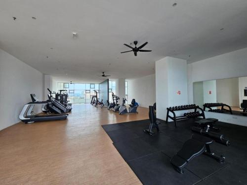 - une salle de sport avec plusieurs vélos d'exercice et un ventilateur de plafond dans l'établissement Newly Furnished Metropol Service Apartment with Attractive View, à Bukit Mertajam