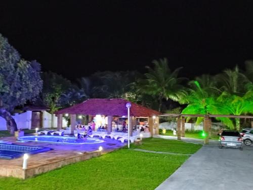 eine nächtliche Aussicht auf einen Pool in einem Resort in der Unterkunft Pousada Villa do Mar in Itaparica Town