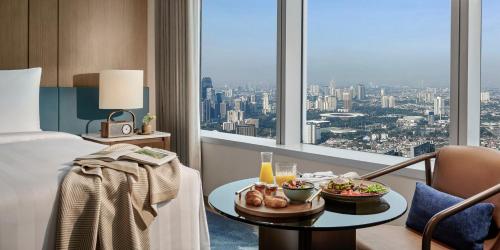 a hotel room with a tray of food on a table at Pan Pacific Jakarta in Jakarta