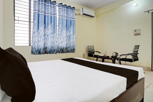 PrayagrajにあるOYO Flagship Hotel Suryaのベッドルーム1室(ベッド1台、テーブル、椅子付)