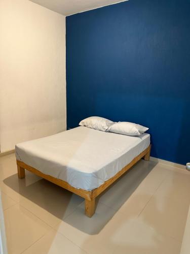 Cama en habitación con pared azul en Depa en Vallarta Fracc. Maralta, en Puerto Vallarta