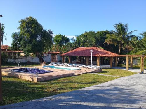une maison avec une piscine et un kiosque dans l'établissement Pousada Villa do Mar, à Itaparica Town