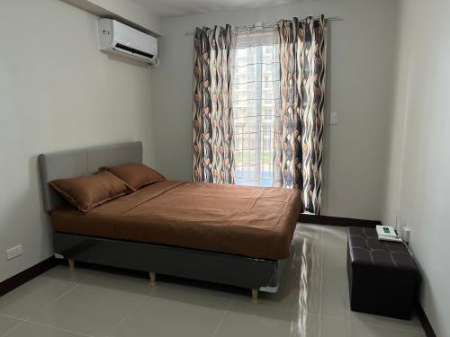 a small bedroom with a bed and a window at Lapu-Lapu City Condo in Lapu Lapu City
