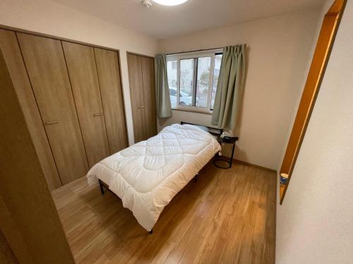 San-I 合浦公園 في Hanazonomachi: غرفة نوم صغيرة بها سرير ونافذة