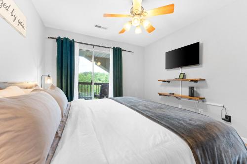 1 dormitorio con 1 cama, ventilador de techo y TV en Lizzy's Landing en Branson