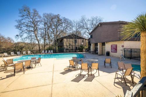 a patio with a table and chairs next to a pool at CW B202 Camp Warnecke B202 in New Braunfels