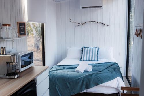 a bedroom with a bed and a desk with a tv at Djindarup Retreat 4 by Tiny Away in Margaret River Town
