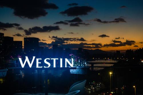 a lit up sign that says westin at sunset at The Westin Fuzhou Minjiang in Fuzhou