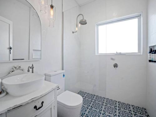 a white bathroom with a sink and a toilet at Lauriston Charmer in Kyneton