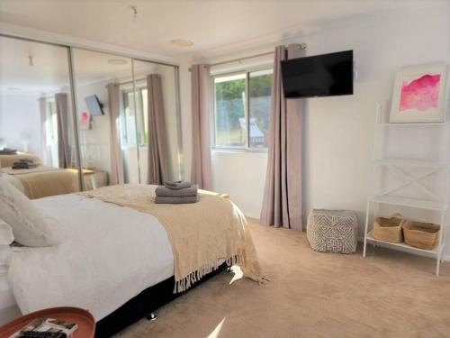 a bedroom with a bed with a television on the wall at Delaware Retreat in Mount Panorama