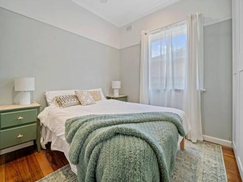 a white bedroom with a bed and a window at Lauriston Charmer in Kyneton
