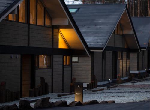 a house with a sign in front of it at Villa Metsä KARUIZAWA ヴィラメッサ軽井沢 in Karuizawa