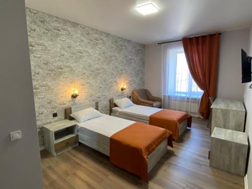 una camera d'albergo con due letti e una sedia di Mini-hotel in Odessa Yard a Odessa