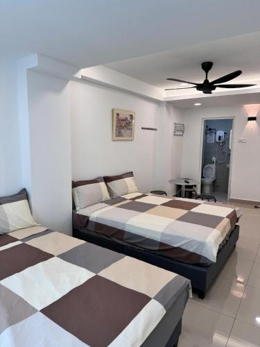 a bedroom with two beds and a ceiling fan at Famosa 2 Stay at Ong Kim Wee in Melaka