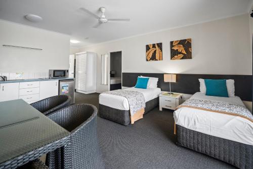 Ένα ή περισσότερα κρεβάτια σε δωμάτιο στο Colonial Palms Motor Inn