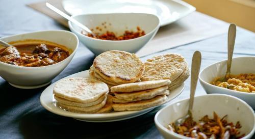 a table with plates of food and bowls of food at Rock View Sinharaja in Kalawana