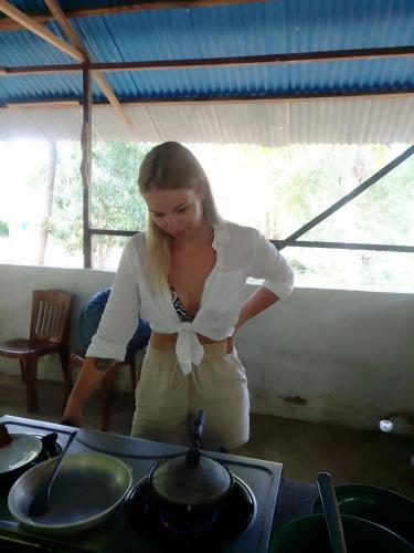 a woman standing in front of a stove at Peacock Residence & Cabana's in Tangalle