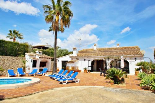 a patio with lounge chairs and a swimming pool and a house at Finca Coello - charming, Spanish finca style holiday villa in Benissa in Benissa
