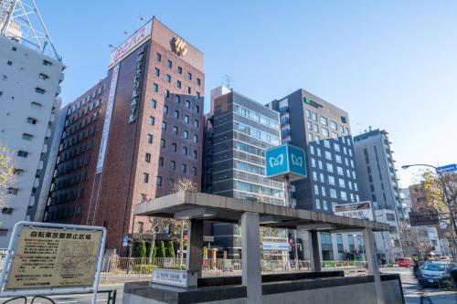 un panneau devant quelques grands bâtiments dans l'établissement Ginza Capital Hotel Akane, à Tokyo