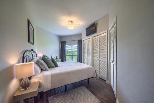 een slaapkamer met een bed met een lamp en een raam bij IC 316 Riverfront Bliss in New Braunfels