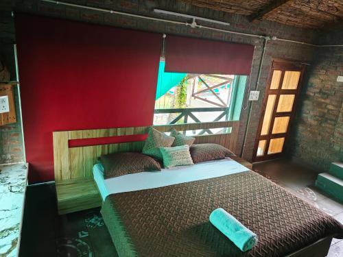 a bed in a room with a red wall at Shobhayan inn in Ayodhya