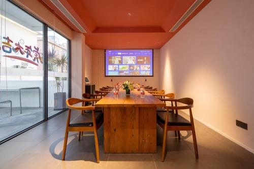 a dining room with a large wooden table and chairs at Hidden Travel Shenzhen Dapeng in Dapeng