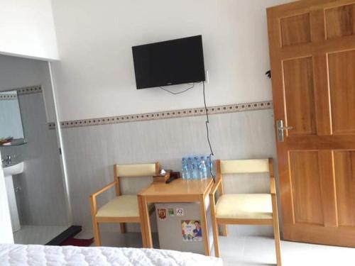 a room with two chairs and a table and a tv at Mỹ Tươi Hotel PQ - by BAY LUXURY in Phu Quoc
