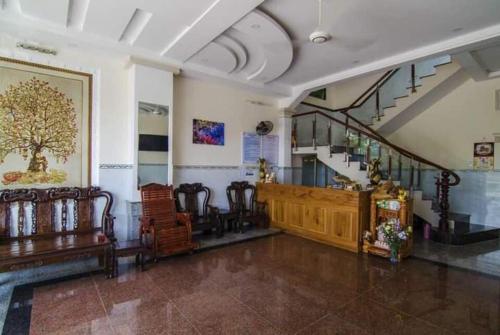 a room with chairs and a staircase in a building at Mỹ Tươi Hotel PQ - by BAY LUXURY in Phu Quoc