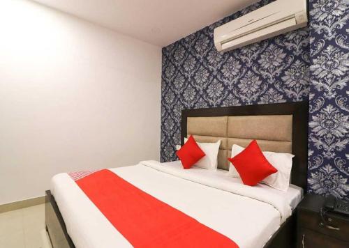 ein Schlafzimmer mit einem großen Bett mit roten Kissen in der Unterkunft OYO Z-heart 2 Near Tughlakabad Station Metro Station in Tughlaqabad