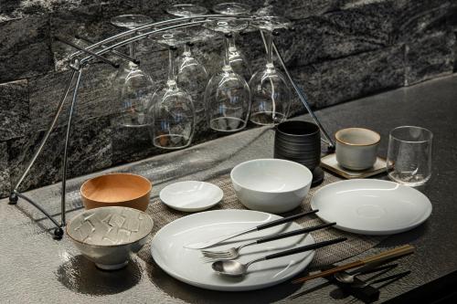 a table with plates and utensils and glass jars at HOTEL MASTAY jingumichi in Kyoto