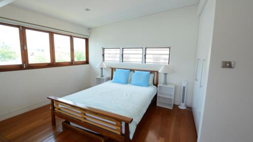 a bedroom with a bed with blue pillows at Connemara Wallabi Point in Wallabi Point