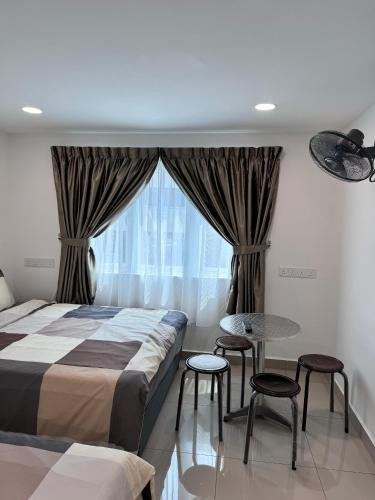 a bedroom with a bed and a table and chairs at Famosa 2 Stay at Ong Kim Wee in Melaka