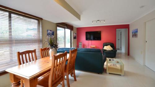 a living room with a blue couch and a table at Brellas On The Beach in Wallabi Point