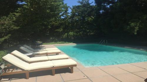 a swimming pool with two lounge chairs and a swimming pool at Villa Perlman in Southampton