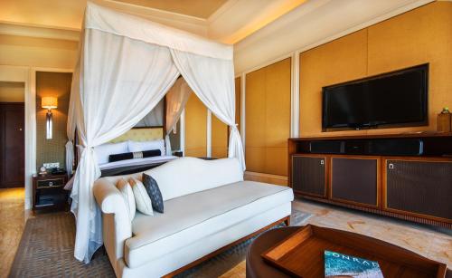 a bedroom with a bed and a flat screen tv at Wanda Reign Resort & Villas Sanya Haitang Bay in Sanya