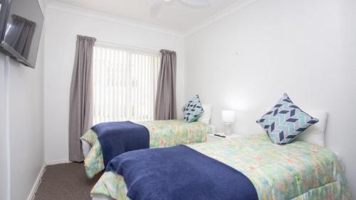 a bedroom with two beds and a window at Apartment 16 - The Meridian in Old Bar