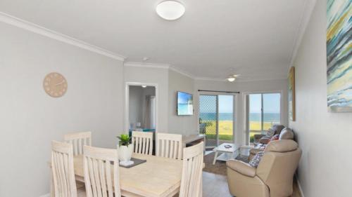 a dining room and living room with a table and chairs at Apartment 14 - The Meridian in Old Bar