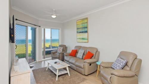 a living room with two couches and a table at Apartment 14 - The Meridian in Old Bar