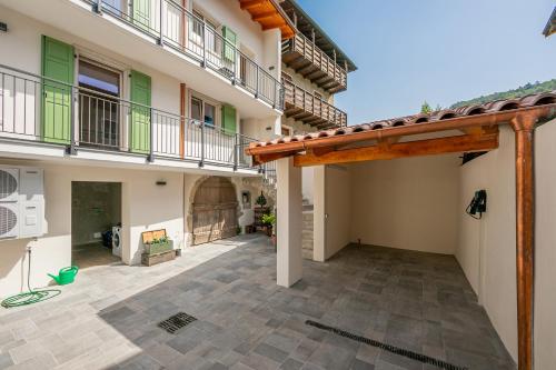 an empty courtyard of a house with a wooden pergola at Casa Del Sole Apartments - Happy Rentals in Arco
