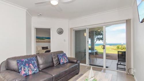 a living room with a couch and a view of the ocean at Apartment 19 - The Meridian in Old Bar
