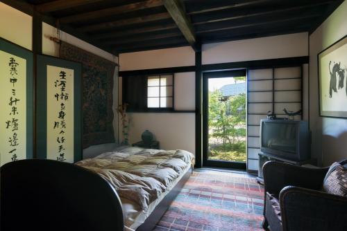 Postel nebo postele na pokoji v ubytování 芸術監督の宿”寂林”