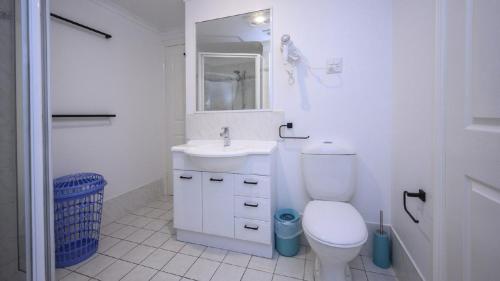 a white bathroom with a toilet and a sink at Apartment 27 - The Meridian in Old Bar