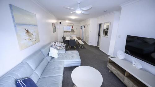 a living room with a couch and a tv at Apartment 27 - The Meridian in Old Bar