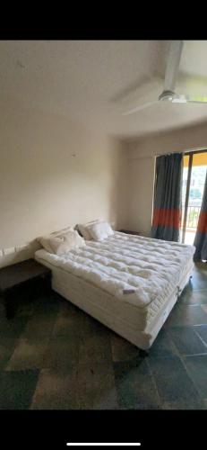 a white bed in a room with a window at 4 bhk lavish lake side property in Lavasa
