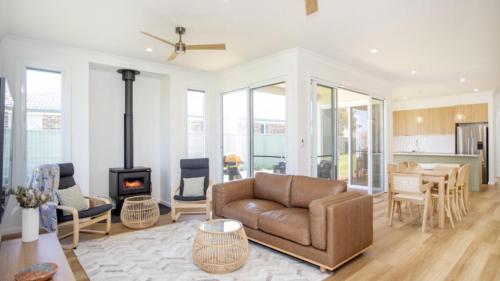 a living room with a couch and a stove at Old Bark House in Old Bar