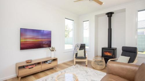 a living room with a couch and a fireplace at Old Bark House in Old Bar