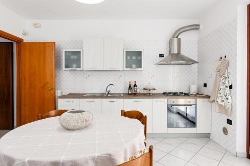 una cocina blanca con una mesa con un tazón. en Casa Dany - Alba - Family Apartment, en Guarene